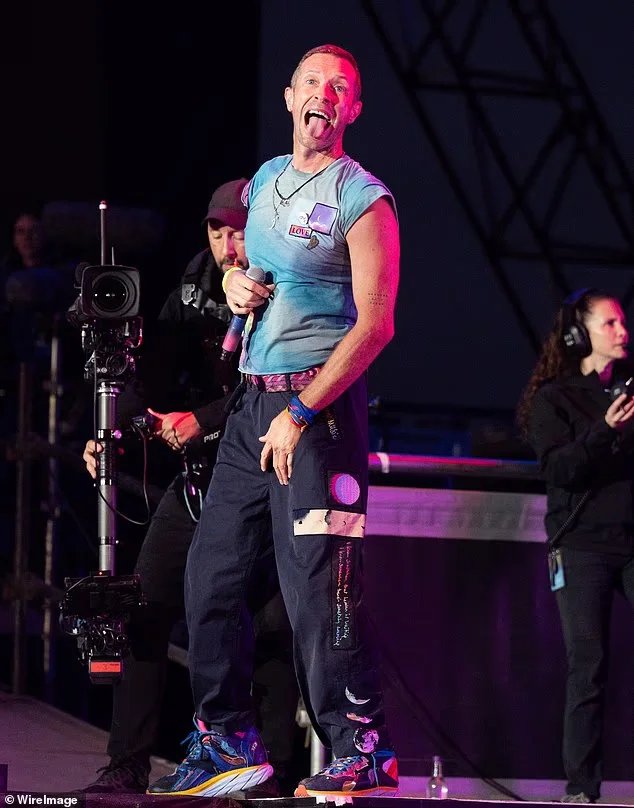Chris Martin wearing one of his signature tie-dyed t-shirts for his performance at Glastonbury in summer 2024