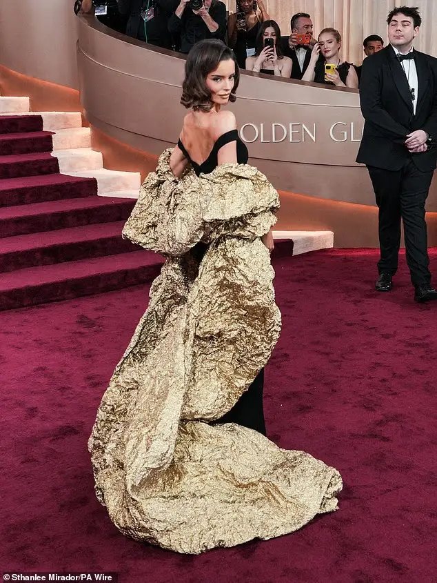 Love Island star Maura Higgins wore quite the over-the-top dress on the Golden Globes red carpet as her black dress featured a crumpled golden cape in the back The cape trailed all the way down to the floor behind her as she kept her short hair in simple curls